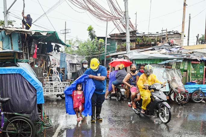 A rescue worker escorted a child during an evacuation of people living along coastal areas in Manila on Sunday.