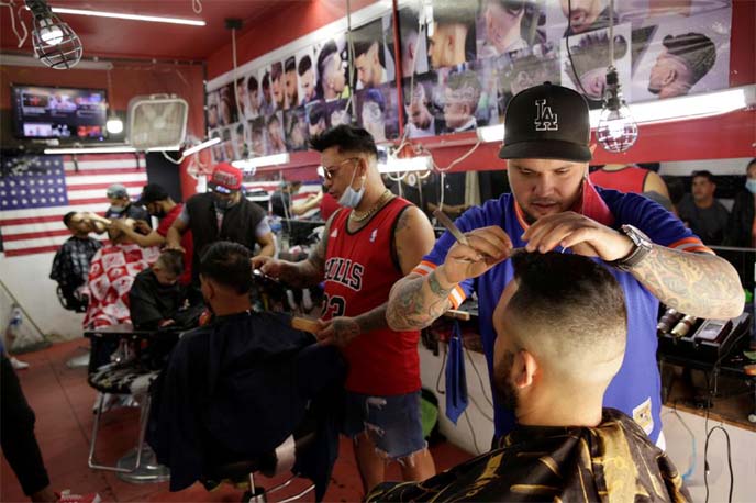 Cuban migrants, under the "Remain in Mexico" program, work in a barbershop while awaiting their immigration hearing in the United States, in Ciudad Juarez, Mexico on Tuesday.