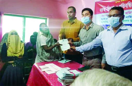Sonagazi UNO Ajit Dev distributes financial assistance and books under the government's social safety-net programme at the Char Darbesh union in Feni district on Thursday.
