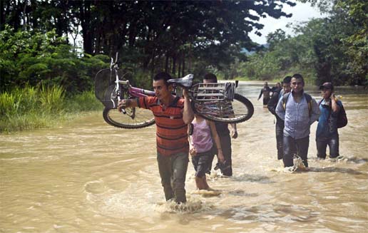People wade through the water in a flooded area in Panzos, Alta Verapaz, 220 km north of Guatemala City on Friday.
