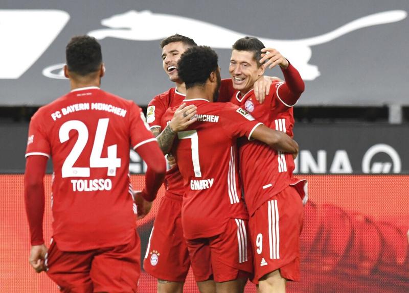 Bayern Munich's Robert Lewandowski (right) celebrates after scoring his side's second goal during the German Bundesliga soccer match against Borussia Dortmund in Dortmund, Germany on Saturday.