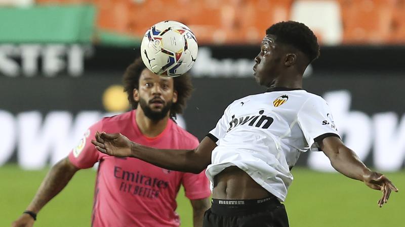 Valencia's Yunus Musah (right) and Real Madrid's Marcelo fight for the ball during the Spanish La Liga soccer match between Valencia and Real Madrid at the Mestalla Stadium in Valencia, Spain on Sunday.