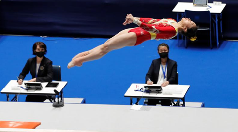 Judges wearing protective masks watch China's Ruiyu Zhou's performance on the balance beam at Friendship and Solidarity Competition, the first international event at a Tokyo Olympic venue since the Games were postponed in March due to the Covid-19 pande