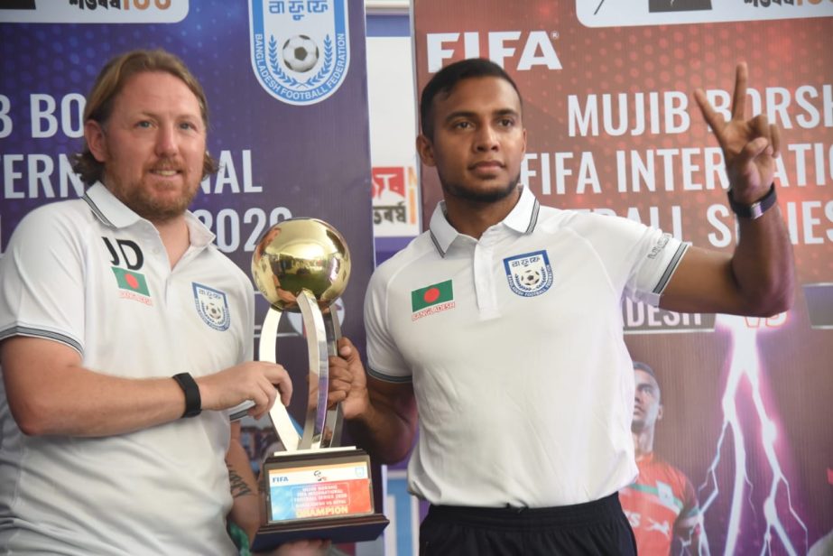 Head Coach of Bangladesh Jamie Day (left) and Captain of Bangladesh Jamal Bhuiyan pose with the trophy of the ' Mujib Borsho' FIFA International Football series at the premises of BFF House on Thursday.