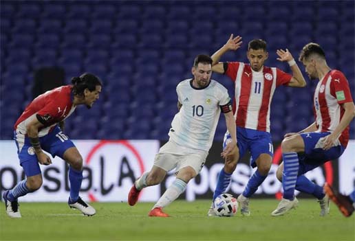 Argentina's Lionel Messi (center) drives the ball next to Paraguay's Angel Romero, right, during their closed-door 2022 FIFA World Cup South American qualifier football match at La Bombonera Stadium in Buenos Aires on Thursday.