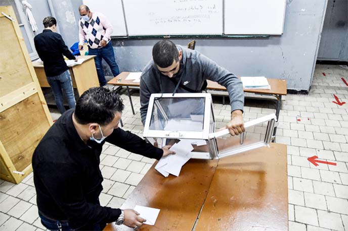 Poll station workers empty a ballot box to begin counting after a vote on a revised constitution ended at a station in Algiers.