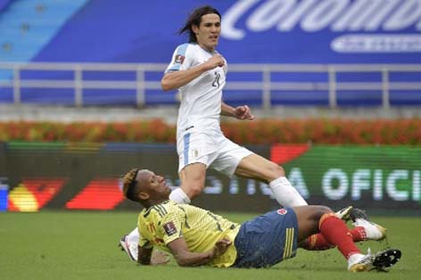 Uruguay's Edinson Cavani shoots the ball past Colombia's Yerry Mina to score the opening goal during their 2022 FIFA World Cup South American qualifier match at the Metropolitan Stadium in Barranquilla, Colombia on Friday.