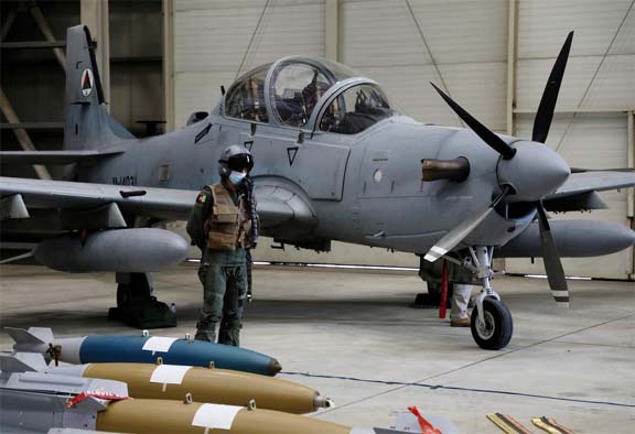 An Afghan pilot stands next to A-29 Super Tucano plane during a handover ceremony of A-29 Super Tucano planes from U.S. to the Afghan forces, in Kabul, Afghanistan.