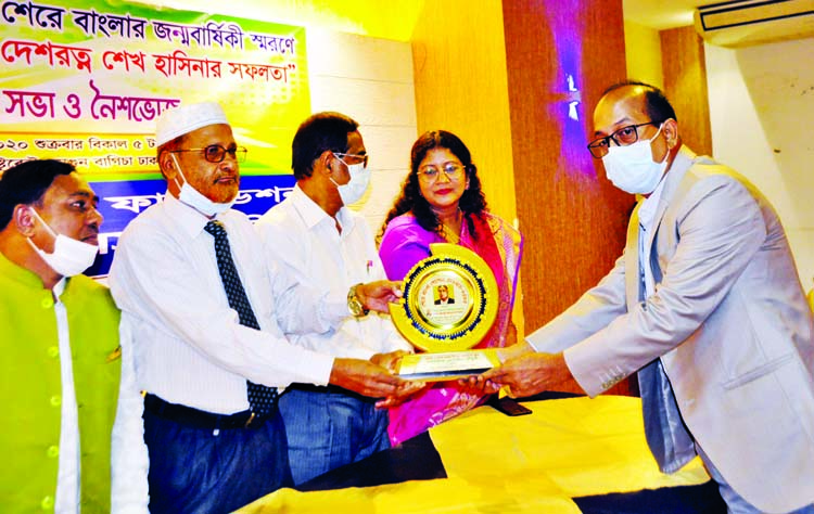 Former Vice-Chancellor of Sher-e-Bangla Agricultural University Prof. Dr. Kamal Uddin Ahmed hands over crest to Golzar Hossain Chowdhury of Sylhet for his contribution in social services at a ceremony organised by Muktijoddhar Santan Foundation at a hotel
