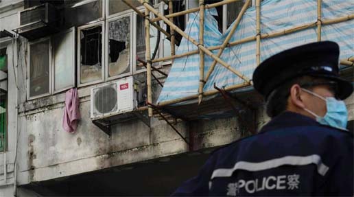 A police officer stands guard at a fire site in Hong Kong on Monday.