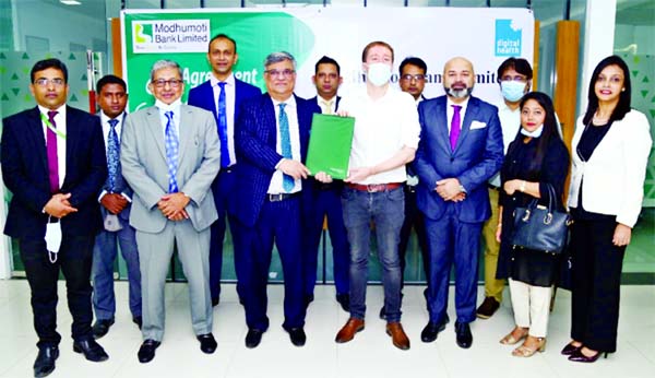 Md. Shafiul Azam, Managing Director and CEO of Modhumoti Bank Limited and Andrew Smith, Founder & Chief Commercial Officer of Digital Healthcare, exchanging an agreement signing document at the bank head office in the city recently. Under the deal, Agent
