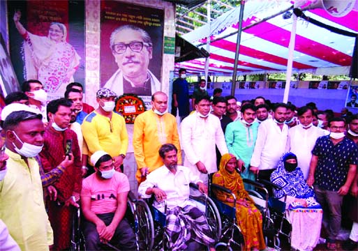 Kamrul Ahsan Sarkar, Convener of Gazipur City Jubo League, distributes wheel chairs among the physically challenged people at a ceremony in front of City Awami League office premises on last Wednesday marking the 48th founding anniversary of Jubo League.