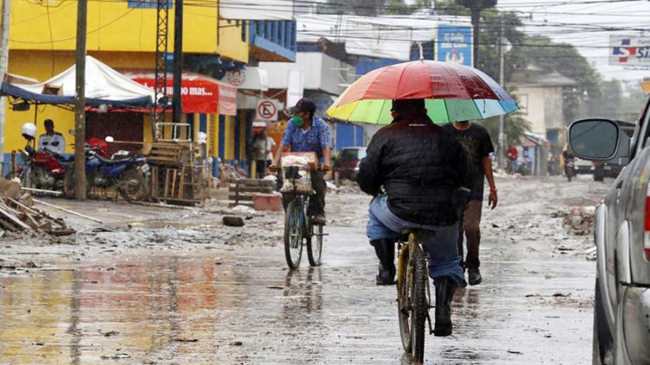 Locals move on street barely cleared from the debris of the last storm, before Hurricane Iota makes landfall in La Lima, Honduras.