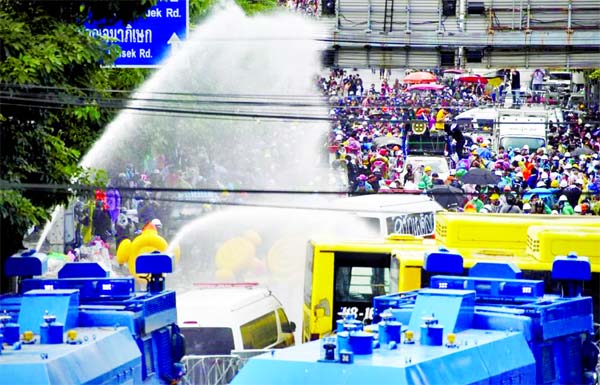 Demonstrators are seen as water cannons are being used during an anti-government protest as lawmakers debate on constitution change, outside the parliament, in Bangkok on Tuesday.