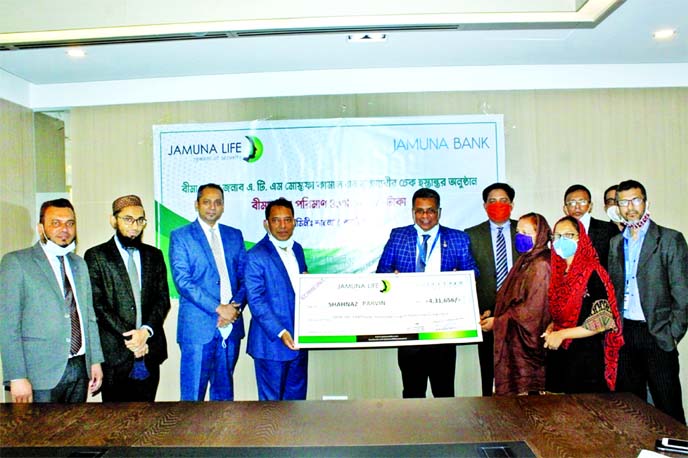 Mirza Elias Uddin Ahmed, Managing Director of Jamuna Bank Limited and Jashim Uddin, Managing Director of Jamuna Life Insurance Company Limited, jointly handing over a claim cheque to a nominee of a Credit Card coverage scheme user who died from normal dis