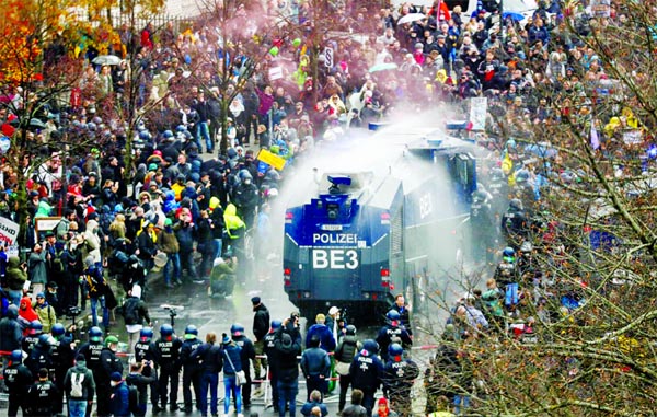 A general view of a protest against the government's coronavirus restrictions, while police use water cannons, near the Reichstag, the seat of Germany's lower house of parliament Bundestag, in Berlin.