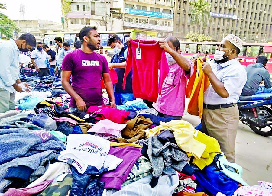People throng footpath shop to buy warm cloths with the advent of winter season. This photo was taken from city's Motijheel area on Thursday.