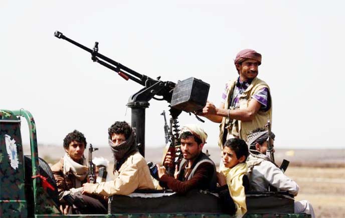 Huthi fighters ride on the back of a patrol truck as they secure the site of a pro-Houthi tribal gathering, in a rural area near Sanaa.