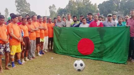 The participants of the exhibition football match with national flag and the guests pose for a photo session at Chakmirpur High School ground in Daulatpur upazila, Manikganj district on Friday.