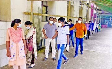 People are seen standing in a long queue on Monday to test coronavirus at the fever clinic of BSMMU amid second wave of the pandemic in the country.