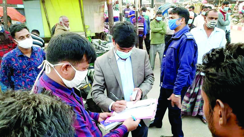 Assistant Commissioner (Land) of Saidpur Upazila and Executive Magistrate Ramiz Alam conducts a mobile court drive at the Bangabandhu Chattar (Panchmatha More) in Saidpur of Nilphamari district on Monday to force people wearing mask.
