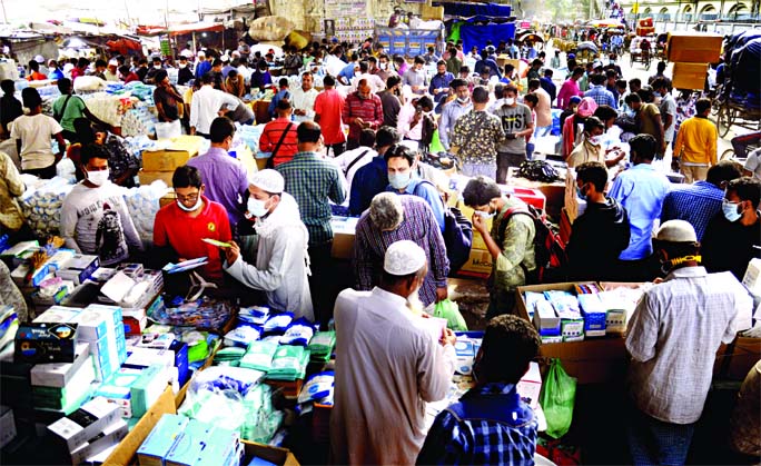 Traders are seen selling Covid-19 safety gears at a makeshift market under Babubazar Bridge in Old Dhaka with total disregard to social distancing norms on Wednesday amid the second wave of coronavirus pandemic striking the country.