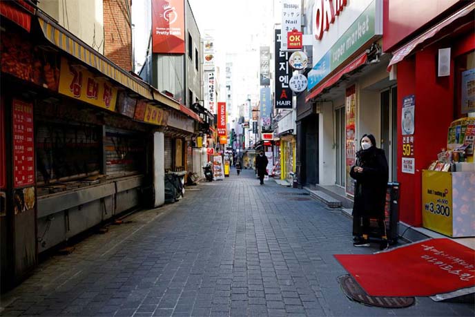 A shopkeeper waits for customers at an empty shopping district amid the coronavirus pandemic in Seoul, South Korea.