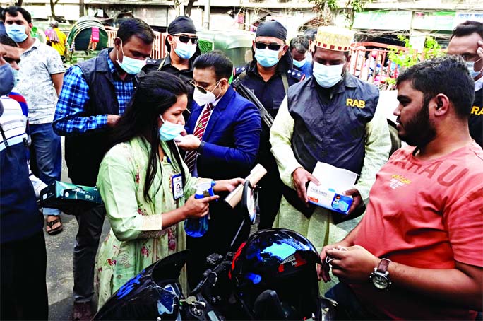 A team of RAB in the city's Shahbagh area is raising awareness among the people about necessity of wearing masks amid Corona pandemic. The photo was taken yesterday.