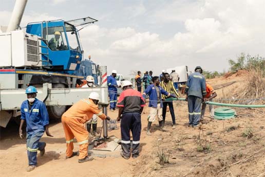 Rescue workers install a water pump to drain water from a mine shaft.