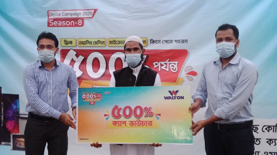 Kabir Ahmed receives the 500 percent cash vouchers on the purchase of a Walton refrigerator at a prgramme held at Walton's distirbutor showroom M/S Amin Electronics at Budhal Bazar in Brahmanbaria Sadar Upazila.