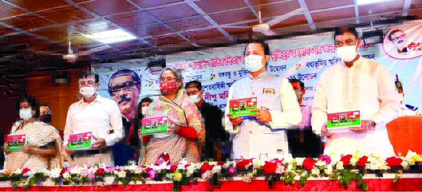 Education Minister Dr. Dipu Moni along with other distinguished persons holds the copies of 'Birth Centenary Souvenir and Annual Calendar-2021' at its unveiling ceremony at the Government Bangla College in the city on Tuesday on the occasion of Mujib Ye