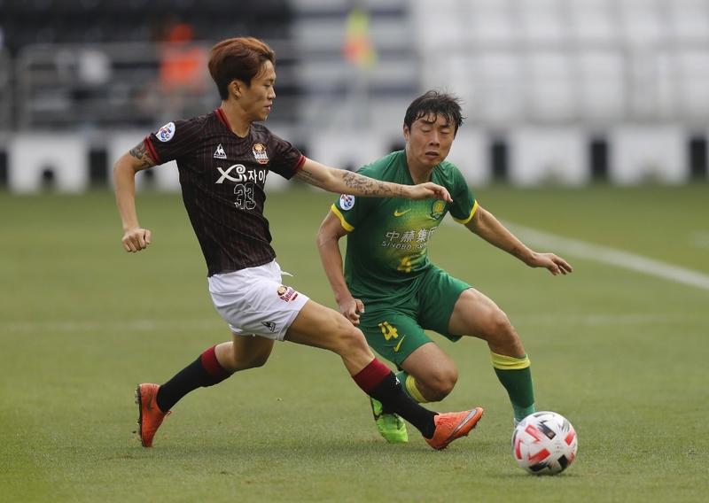 Beijing's defender Li Lei (right) is marked by Seoul's defender Lee In-Gyu during the AFC Champions League, Group E football match between China's Beijing Guoan and Korea's FC Seoul on Monday.