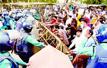 Police intercept a workers' procession of different garment factories in front of the Jatiya Press Club in the capital on Tuesday when they tried to proceed towards Ministry of Labour and Employment demanding arrear salaries of 11 months.