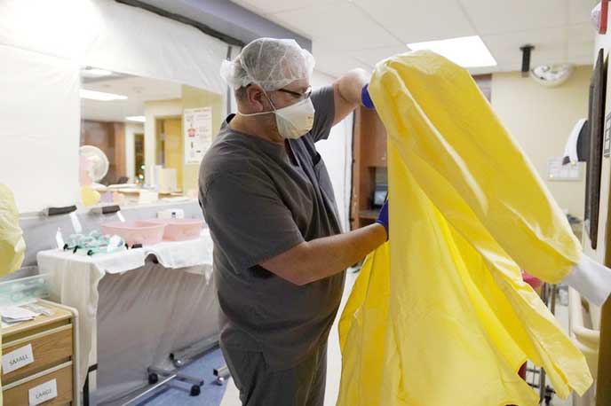 A man puts on personal protective equipment before performing rounds in a portion of Scotland County Hospital set up to isolate and treat COVID-19 patients in Memphis, Mississippi, US.