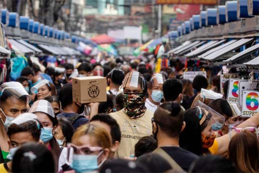Filipinos wearing masks and face shields for protection against the coronavirus walk along a street market in Manila, Philippines.