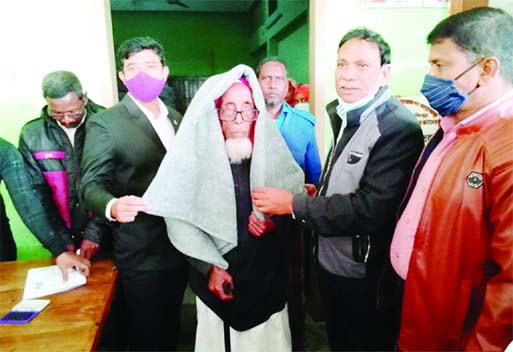 Azizul Islam, Chairman of Gajaghanta union parishad (Gangachara Upazila) in Rangpur distributes blanket among the cold-hit people in the area on Monday.