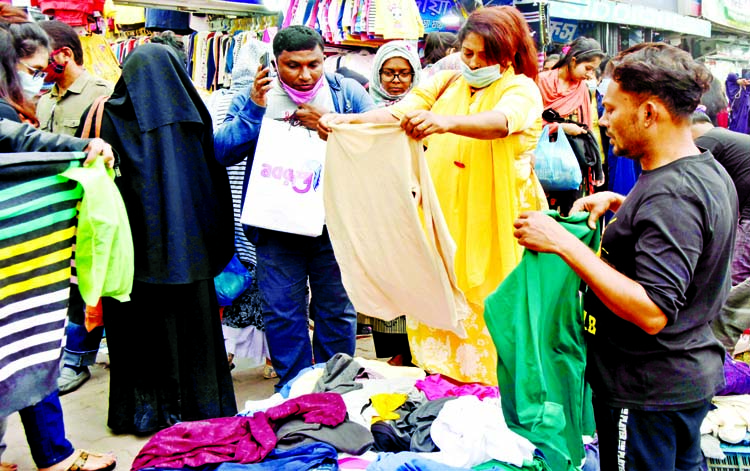 Buyers browse for winter cloths at a footpath shop in the capital's New Market area in the wake of foggy weather on Wednesday.