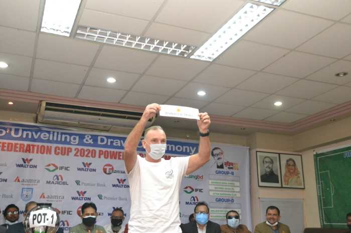 Head Coach of Dhaka Mohammedan Sporting Club Sean Lane picking a name of the participating teams of the upcoming Federation Cup Football during a draw ceremony at the conference room in the Bangladesh Football Federation House on Sunday.