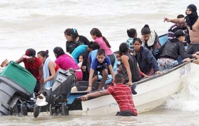 Venezuelan migrants, who were recently deported, arrive at shore on Los Iros Beach, in Trinidad and Tobago.