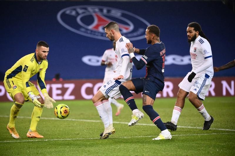 Paris Saint-Germain's forward Neymar (second right) fights for the ball in front of Lyon's goalkeeper Anthony Lopes (left) during the French L1 football match at the Parc des Princes stadium in Paris on Sunday.