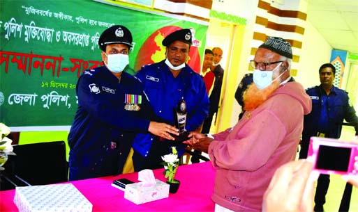 A freedom fighter receives crest from OC of Fulbari Police Station in Mymensingh at a reception accorded to freedom fighters on Wednesday marking the Victory Day.