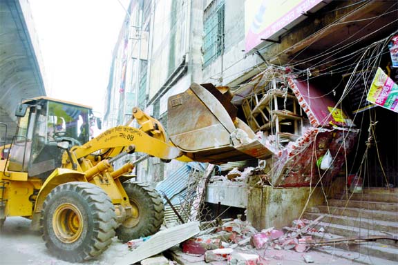 A bulldozer of Dhaka South City Corporation (DSCC) demolishes illegal structure from the capital's (Gulistan) Sundarban Super Market and its surrounding areas in a drive on Thursday..