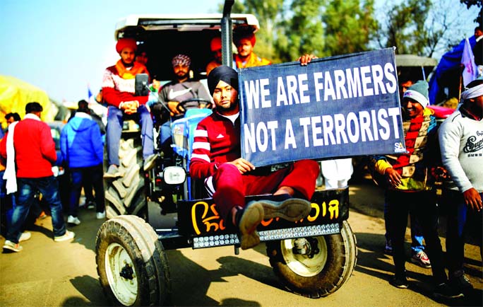 Farmers arrive in a tractor to attend a protest against the newly passed farm bills at Singhu border near New Delhi, India.