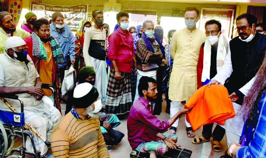 Kazi Manrul Islam Manu, MP of Dhaka-5 constituency distributes winter clothes among the cold-hit poor people organised by Joy Bangla Sangskritik Jote in the city's Wari area on Saturday.