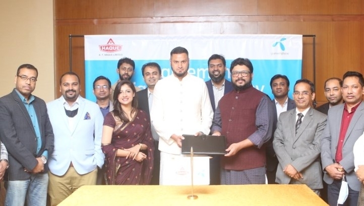 Kazi Mahboob Hasan, Divisional Head (Business) of Grameenphone and Adam Tamizi Haque, Managing Director of Haque Group, exchanging an agreement signing document. Under the deal, Grameenphone will provide comprehensive ICT solution for digitalization to Ha