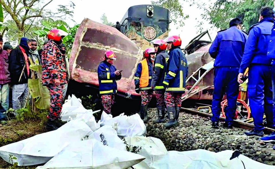 Rescuers stand by the damaged bus after a deadly crash with a Rajshahi-bound train at a level crossing in Sadar upazila of Joypurhat district on Saturday morning.