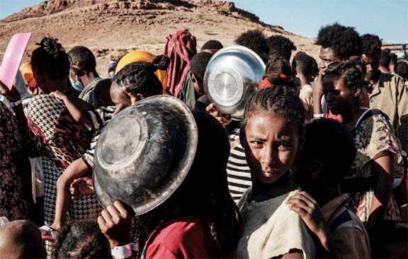 Ethiopian refugee children who fled the Ethiopia's Tigray conflict wait in a line for a food distribution in Sudan's eastern Gedaref state.