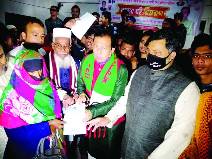 Jahangir Alam, Vice-President of Noakhali District unit Awami League, distributes books of social safety-net programmes among the beneficiaries of seven unions in Sonaimuri Upazila of Noakhali district at a function on Sunday.