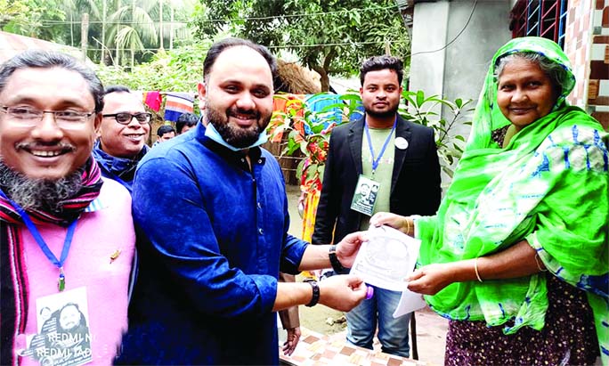 Awami League's mayoral candidate SM Iqbal Hossain Sumon distributes a leaflet to a female voter during an election campaign for Gafargaon municipality election in Gafargaon of Mymensingh district on Sunday.