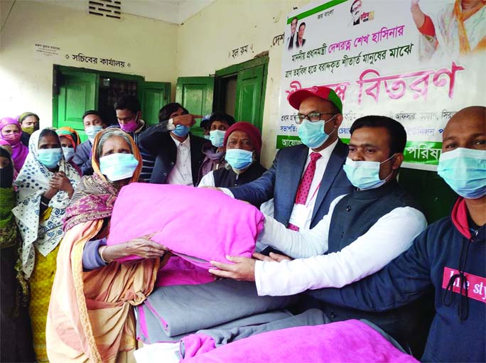 Sirajganj's Tarash UNO Mezbaul Karim along with Sadar Union Parishad Chairman Babul Sheikh distribute blanket allocated from the Prime Minister's Relief Fund among the families in the area on Monday morning.